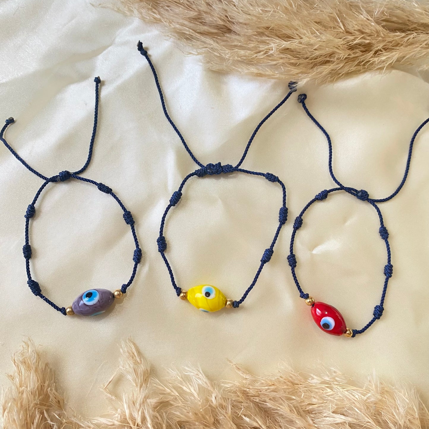 Hilo 7 nudos azul y dije ojo turco en morado, amarillo y rojo